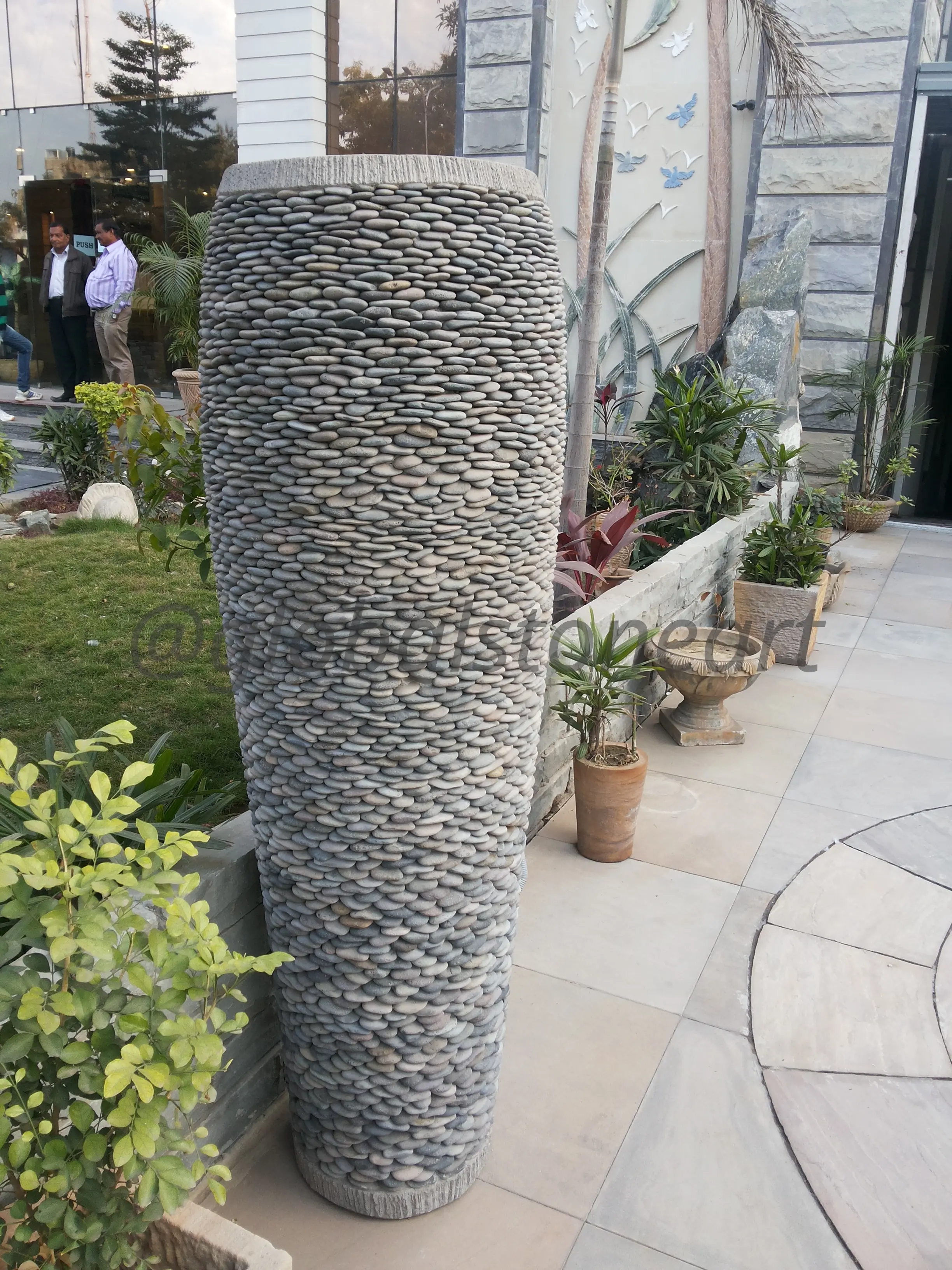 Pebble-Clad Tall Cylinder Planter for Courtyard